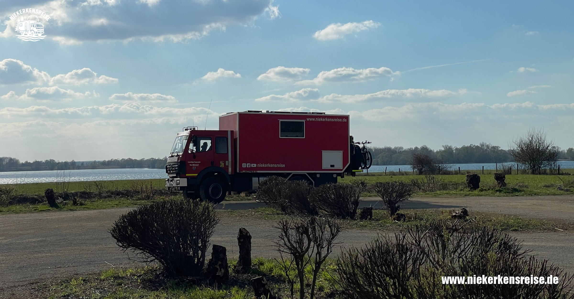 Selbstausgebauter Feuerwehr-LKW Mercedes Benz 1224 als Expeditionsmobil auf einem ruhigen Stellplatz am Wasser in Europa