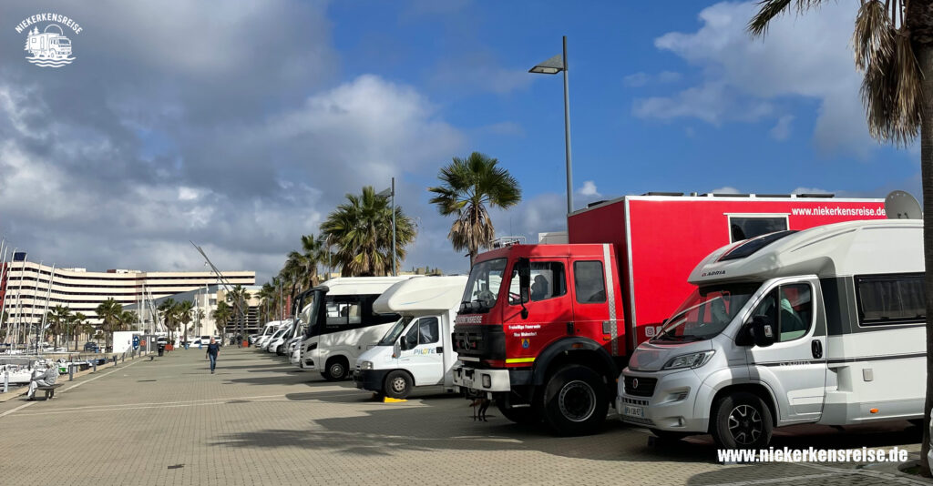 Wohnmobilstellplatz bei Gibraltar mit Blick auf den Hafen – Expeditionsmobil von niekerkensreise zwischen Wohnmobilen an der Promenade