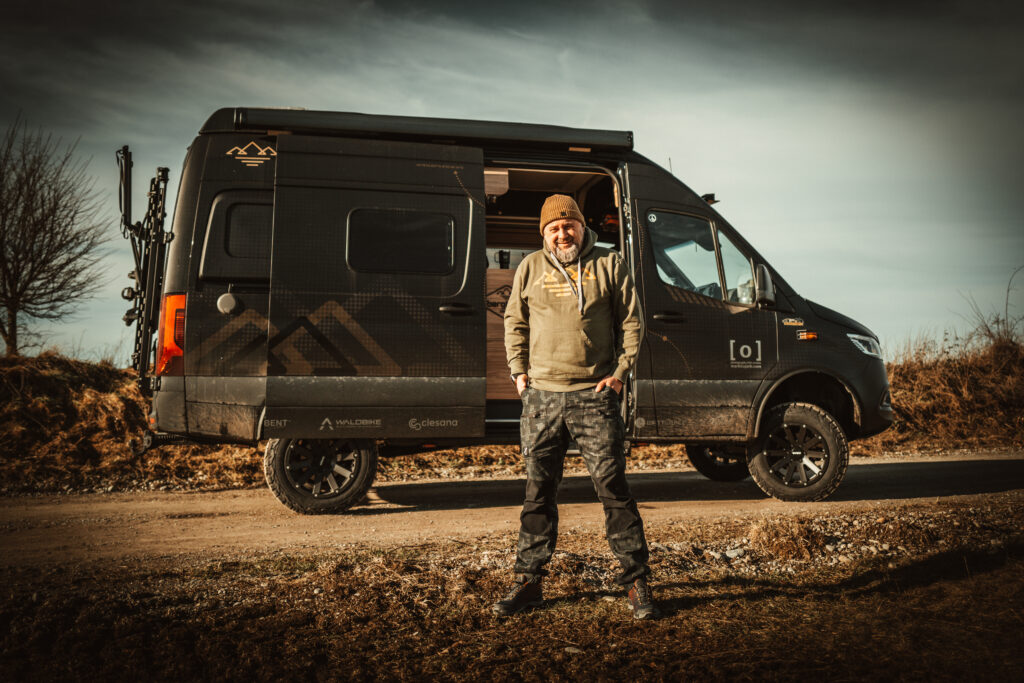 Mark von Bergbrise Camping vor seinem schwarzen Camper – Wohnmobil-YouTuber mit Fokus auf Autarkie, Technik und Reisen.