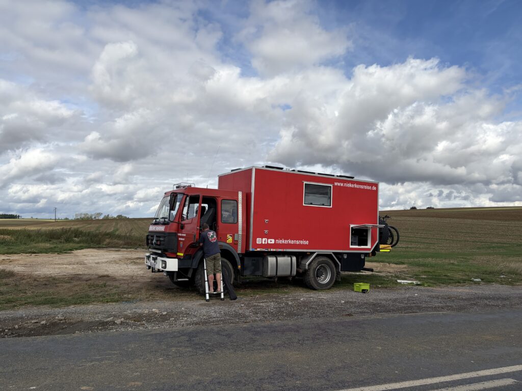 Roter Mercedes-Benz 1224 von Niekerkensreise bei einer Pause an einer französischen Landstraße auf der mautfreien Route in die Bretagne.