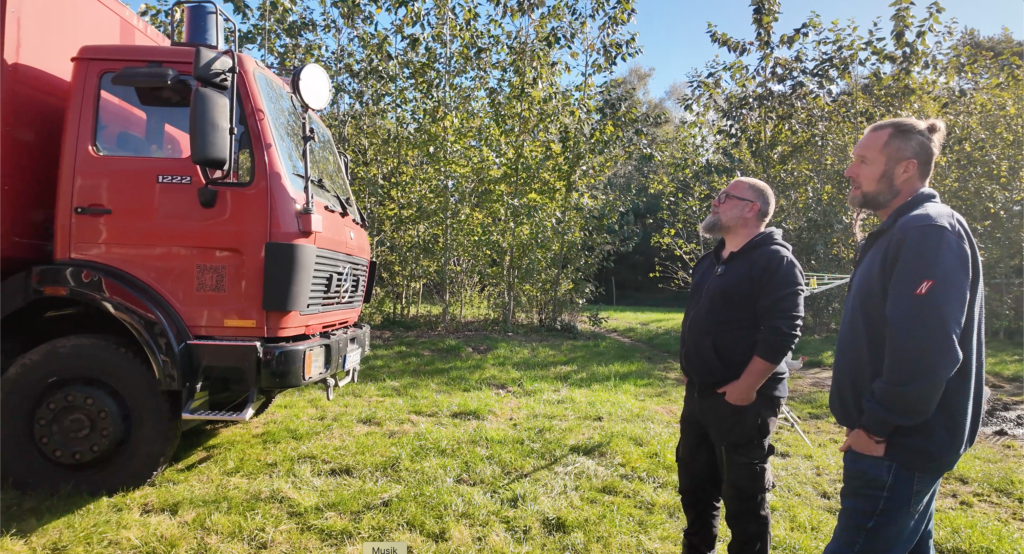 Andre und Lars von Niekerkensreise begutachten den roten Mercedes-Benz 1222 „Otto“, einen zum Wohnmobil umgebauten ehemaligen Feuerwehr-Rüstwagen.