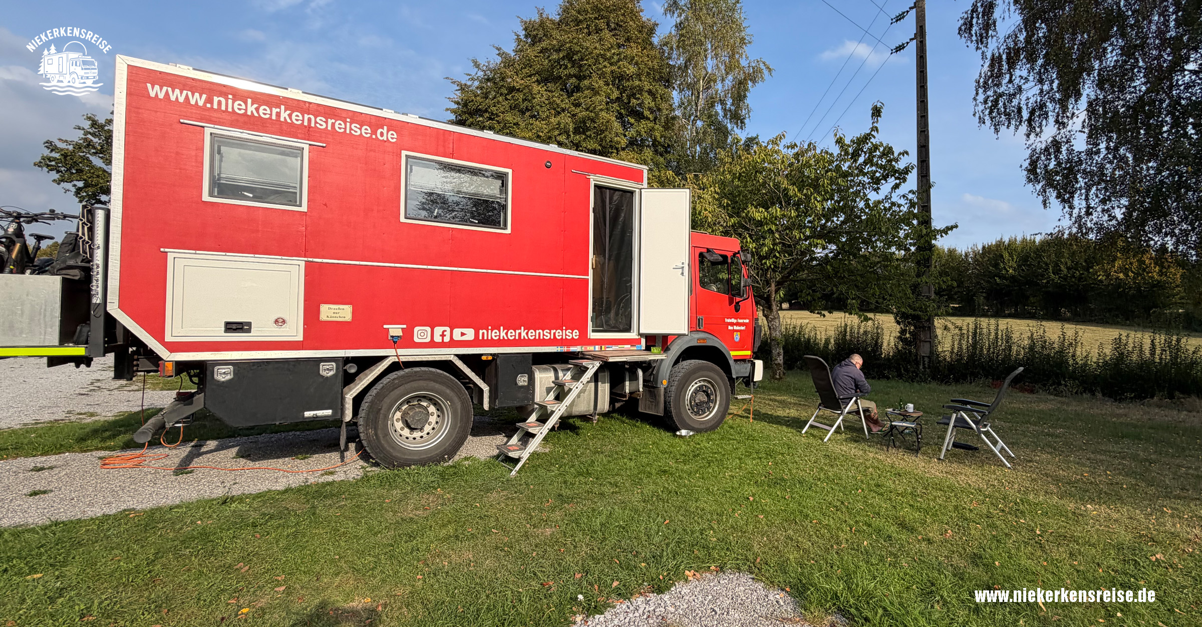 Niekerkensreise auf dem Wohnmobilstellplatz Felleries in Nordfrankreich Roter Expeditions-LKW auf dem Camping-Car-Park-Wohnmobilstellplatz in Felleries, Nordfrankreich.