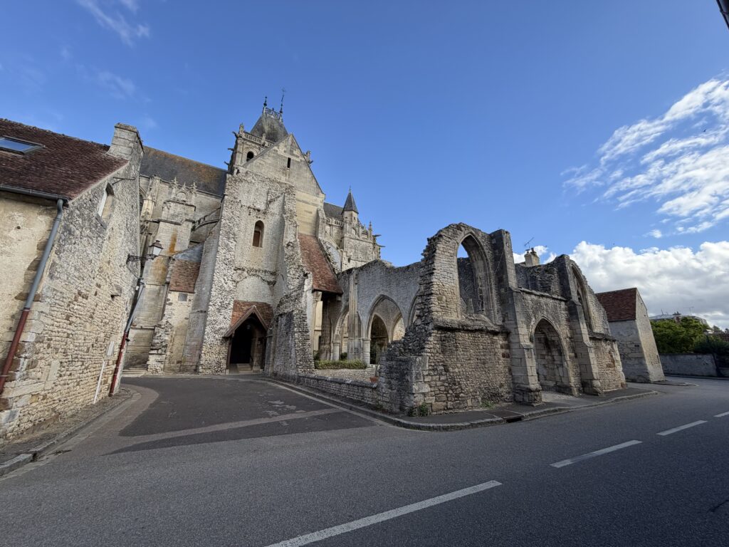 Historische Kirche Saint-Martin in Écouché-les-Vallées in der Normandie, Frankreich, mit mittelalterlichen Steinmauern, gotischen Spitzbögen und teilweise erhaltenen Kirchenruinen.