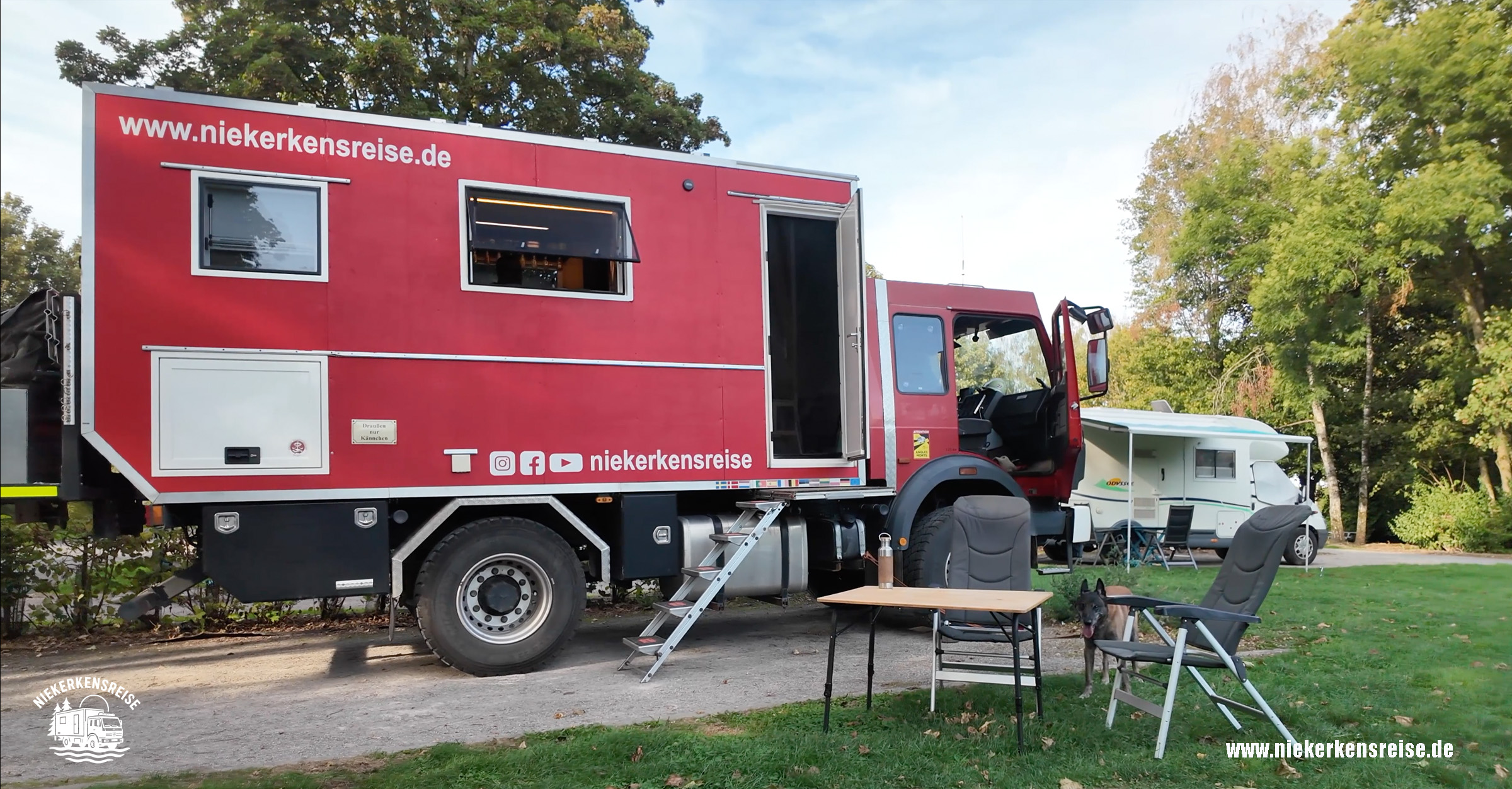 Kostenloser Wohnmobilstellplatz Solre-le-Château in Nordfrankreich – Niekerkensreise Rotes Expeditionsmobil Mercedes-Benz 1224 AF von Niekerkensreise auf dem kostenlosen Wohnmobilstellplatz Solre-le-Château in Nordfrankreich, mit Campingmöbeln und Hund Elvis.